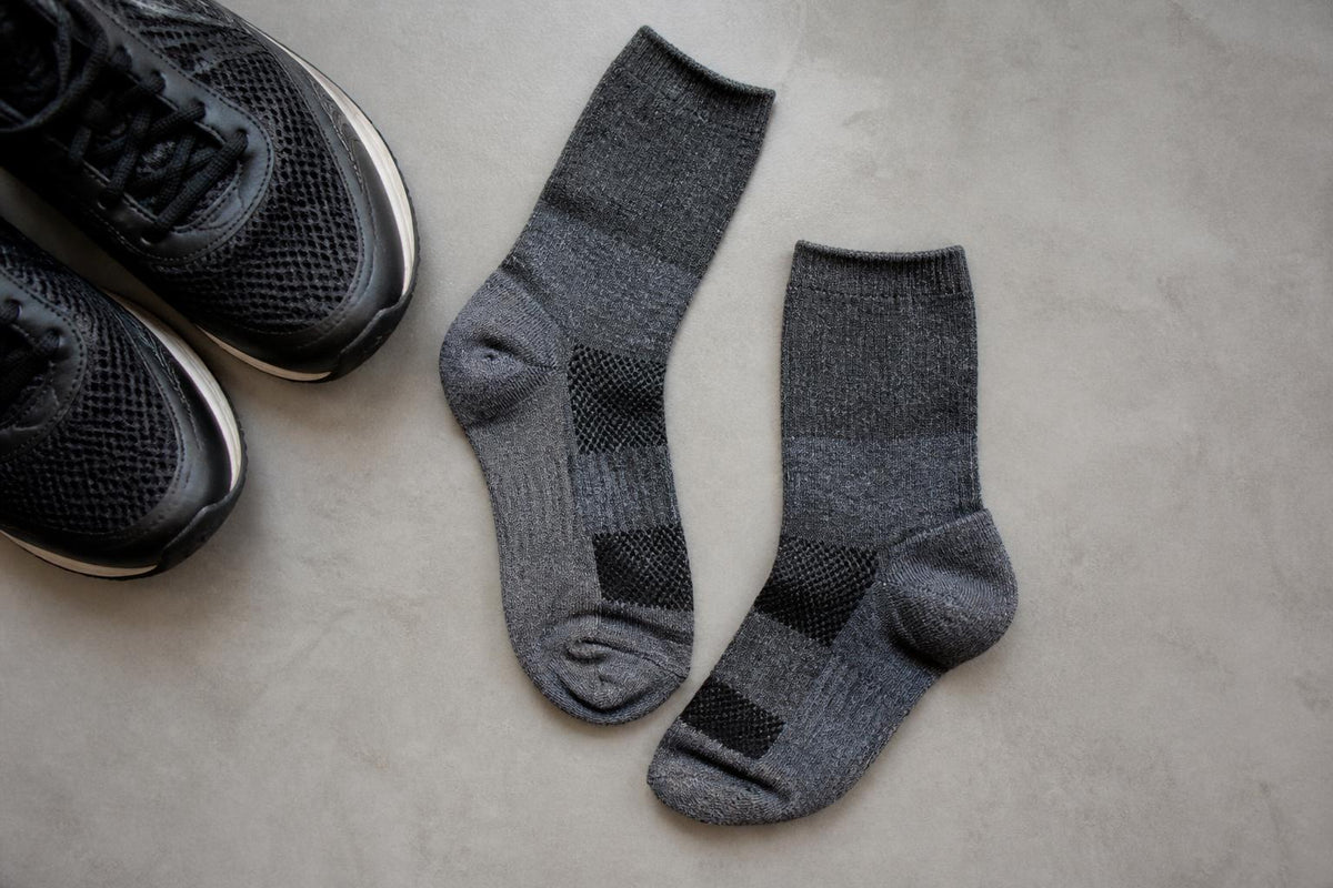 Close-up of a runner's foot wearing a snug, moisture-wicking athletic sock inside a breathable mesh running shoe